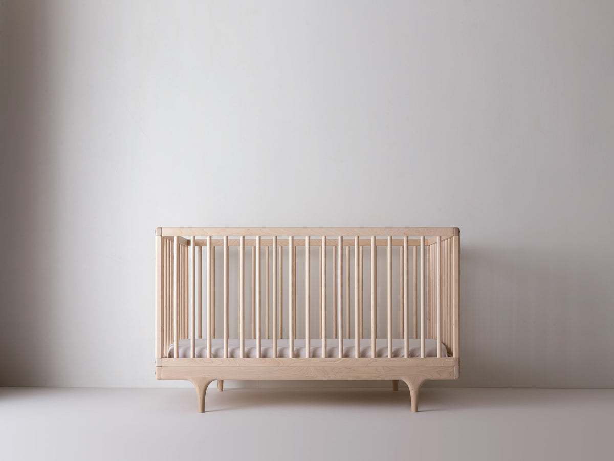 Caravan Crib in ash, mattress at the lower support height for older babies who can pull themselves up to stand.