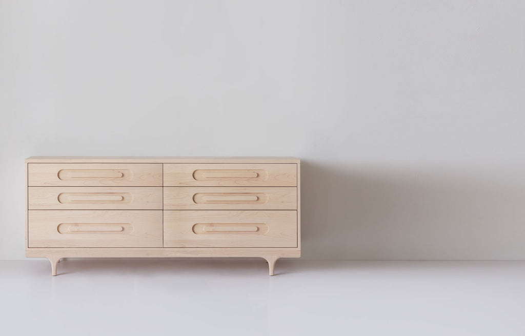Caravan Double Dresser in ash, front view on a white studio floor, six drawers in two columns and sculpted Crib-style legs.