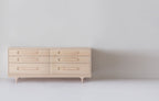 Caravan Double Dresser in ash, front view on a white studio floor, six drawers in two columns and sculpted Crib-style legs.