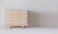 Caravan Dresser in ash, front view on a white studio floor, three drawers with oblong recessed pulls and sculpted legs.