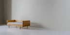 Caravan Divan in white oak with walnut caps, backrest configuration, off-center to the left on a white studio floor.