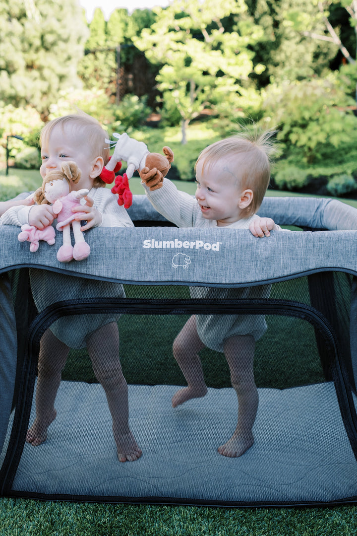 Two toddlers playing in a playard outdoors