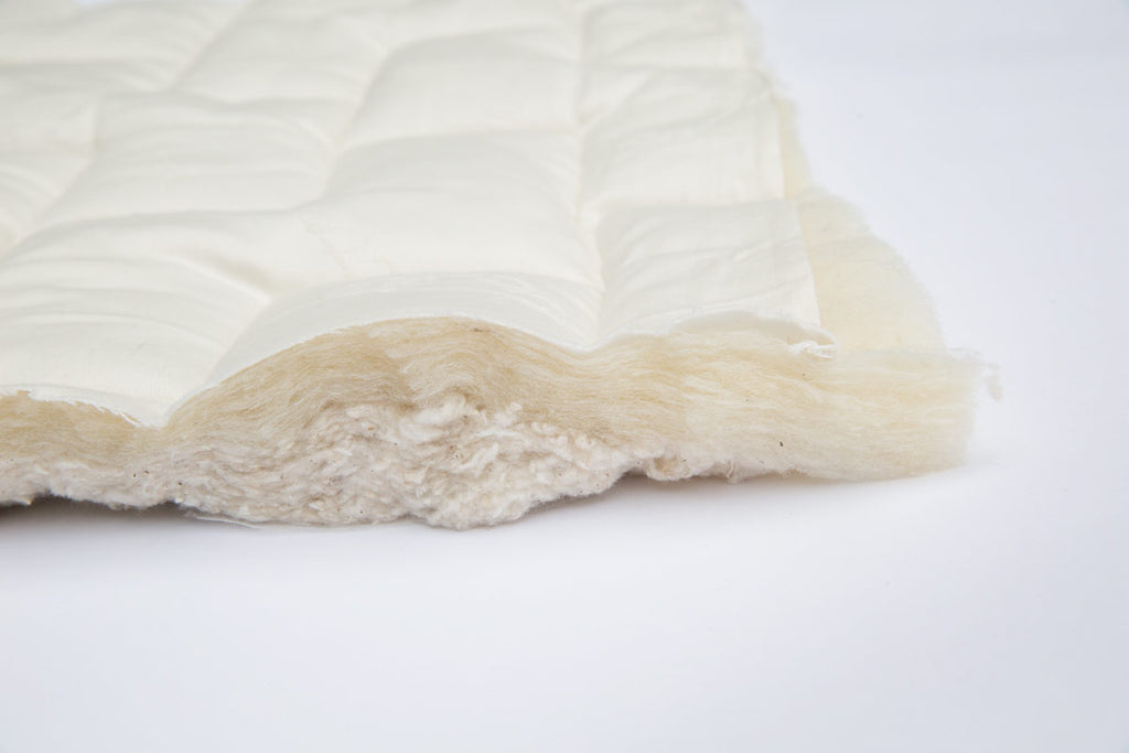 Kalon Organic Mattress with the quilted cotton ticking lifted to show the natural wool batting underneath.
