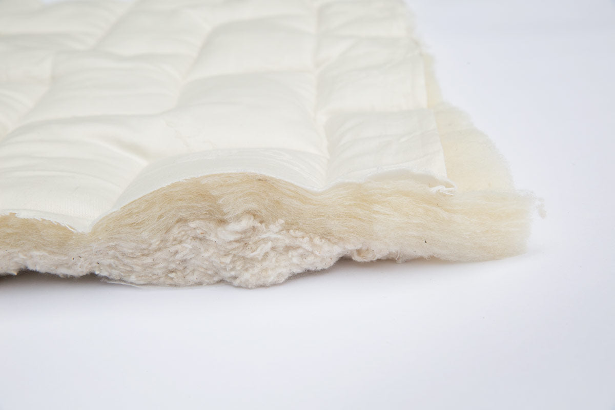 Kalon Organic Mattress with the quilted cotton ticking lifted to show the natural wool batting underneath.
