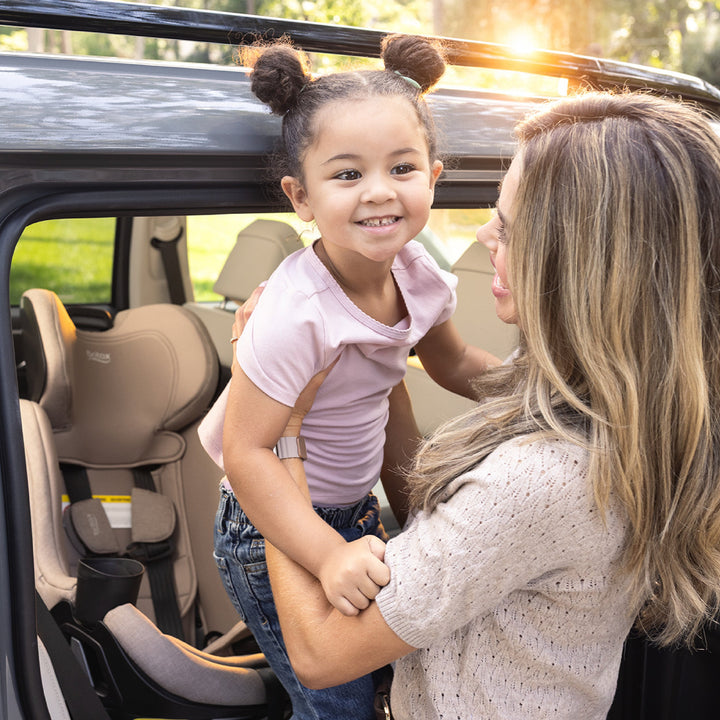 Parent lifting a child at a Galaxy360 car seat, Britax