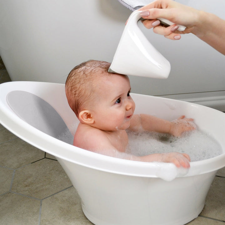 Baby in a Shnuggle bath having its hair rinsed
