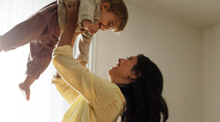 Mother lifting her smiling baby
