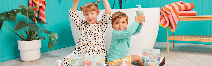 Two children in a bathroom with Dabble & Dollop bath products