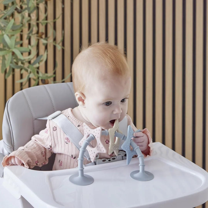 Baby in a high chair playing with a suction toy