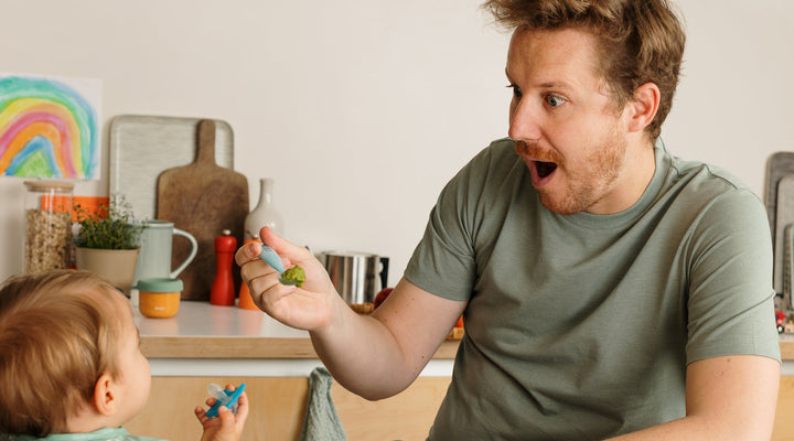 Father feeding his child in the kitchen