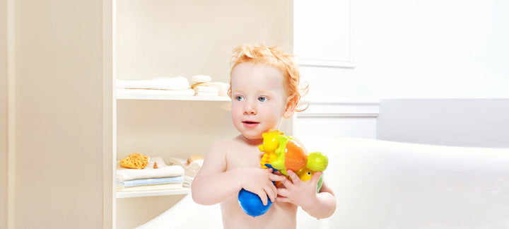 Toddler holding CaaOcho natural rubber bath toys