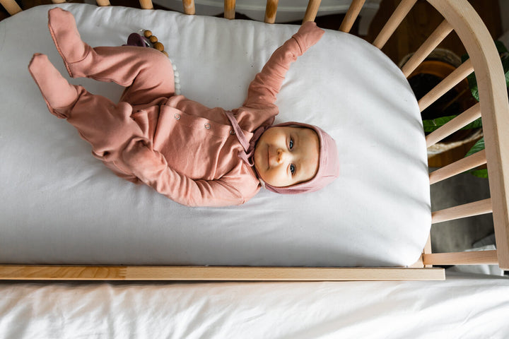 Baby lying in a babybay bedside sleeper