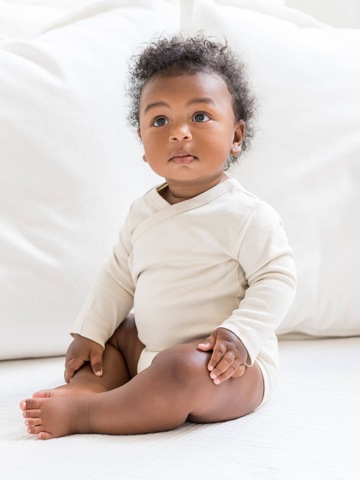 Baby sitting in a Colored Organics Classic Long Sleeve Kimono Bodysuit