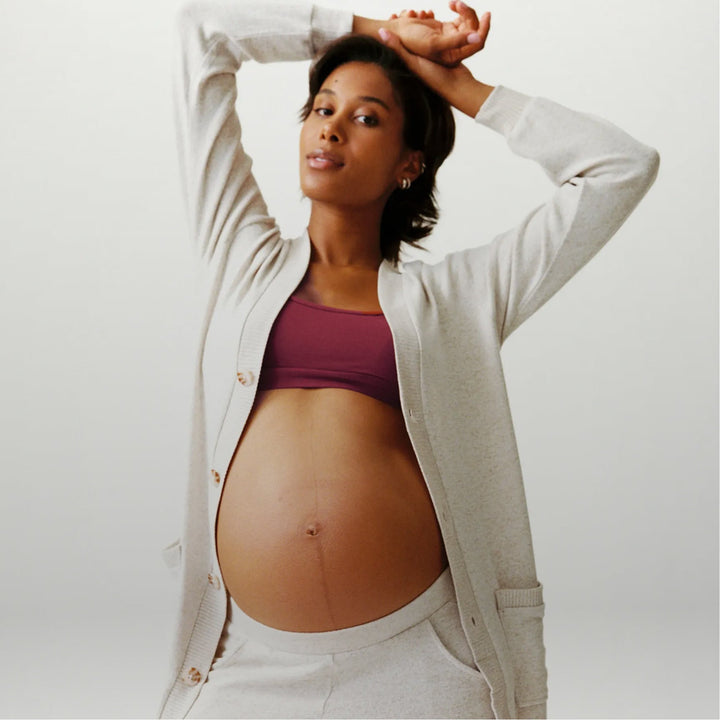 Pregnant woman wearing a Kindred Bravely knit cardigan and bralette