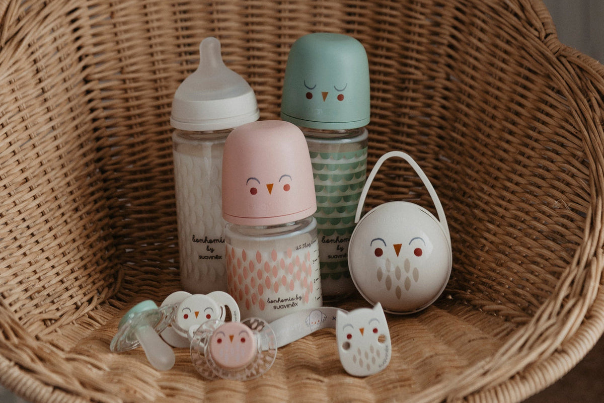 Suavinex Bonhomia glass bottles and pacifiers in a wicker basket