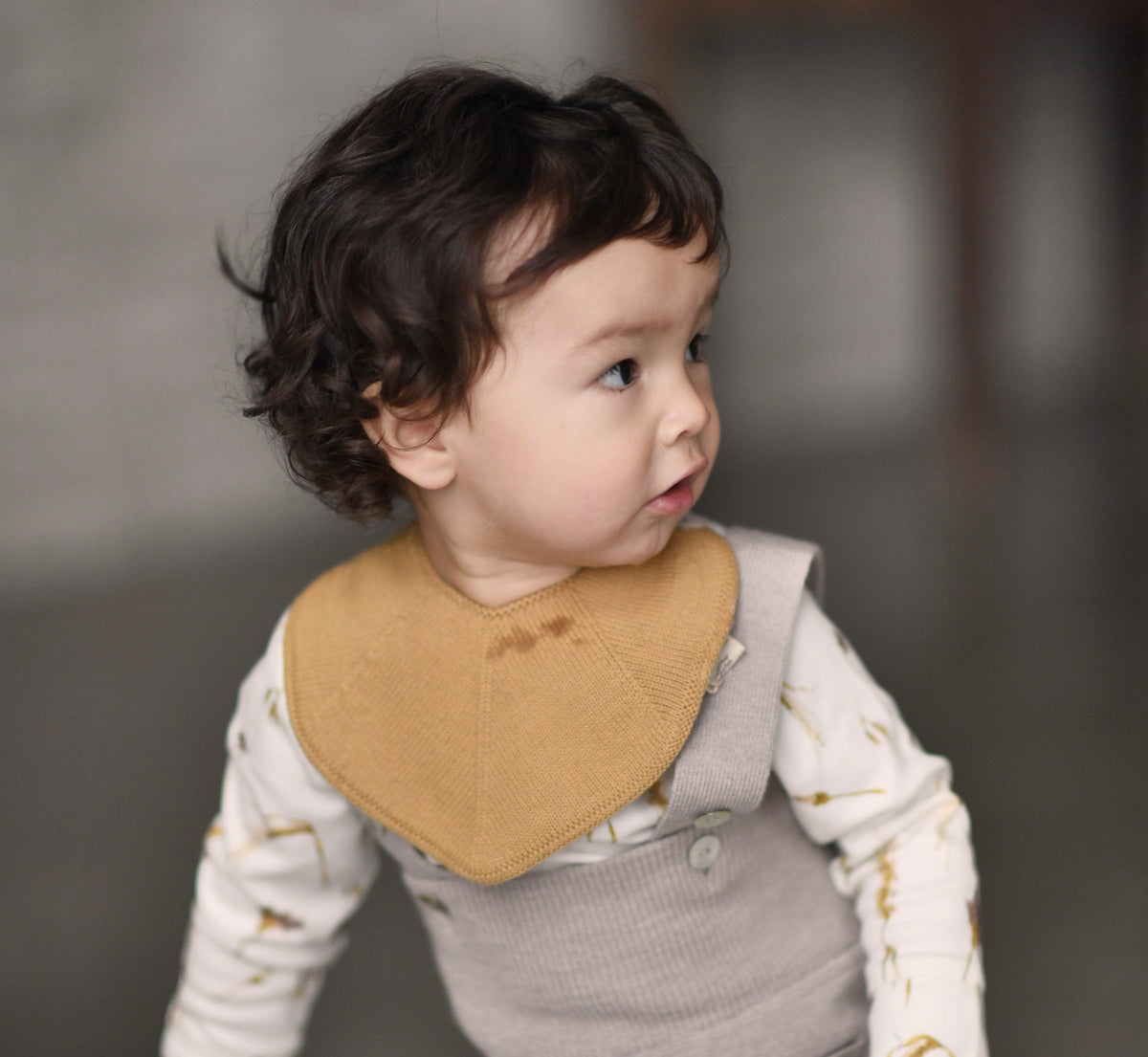Toddler wearing a knitted Saga Copenhagen bib
