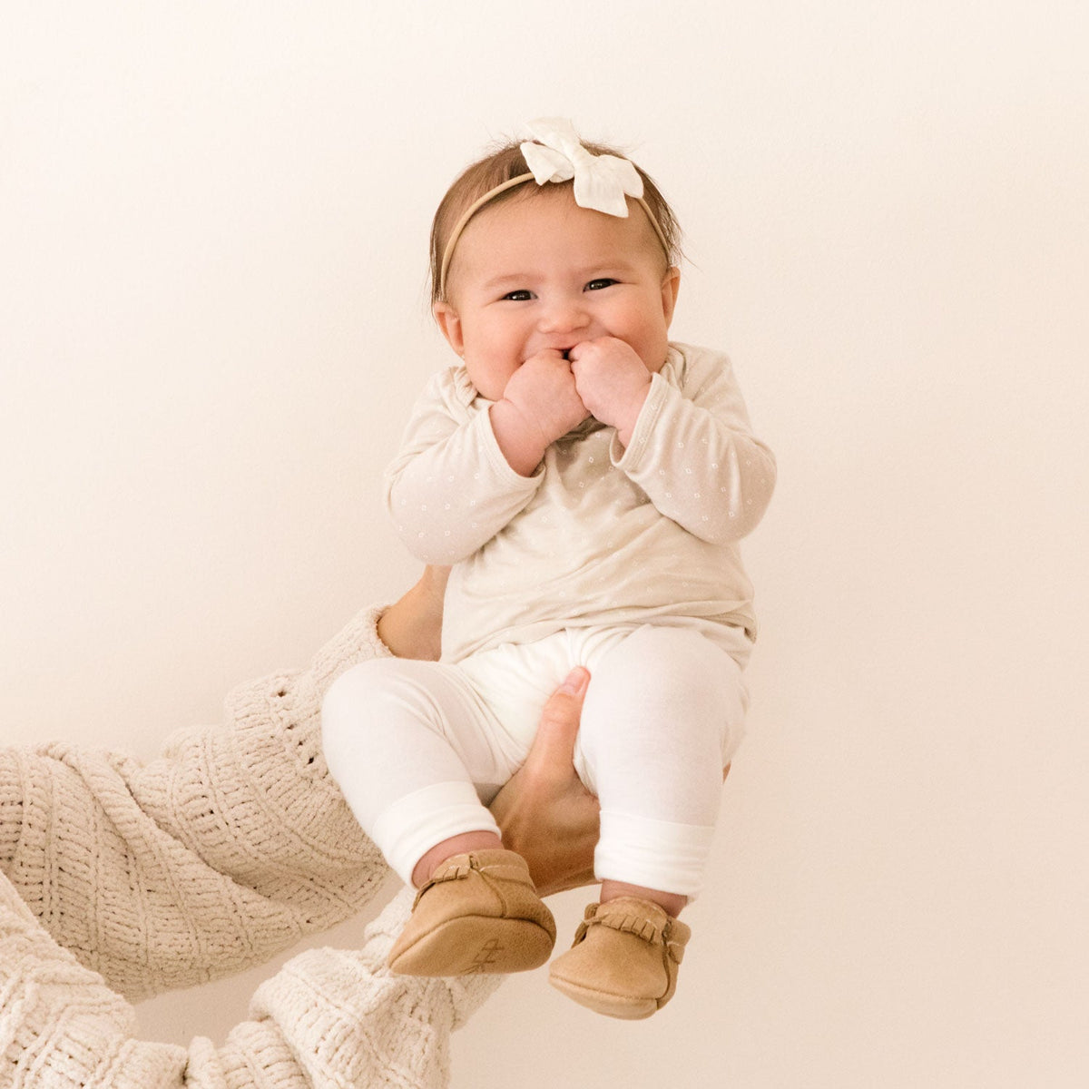 Smiling baby in soft-sole Freshly Picked moccasins