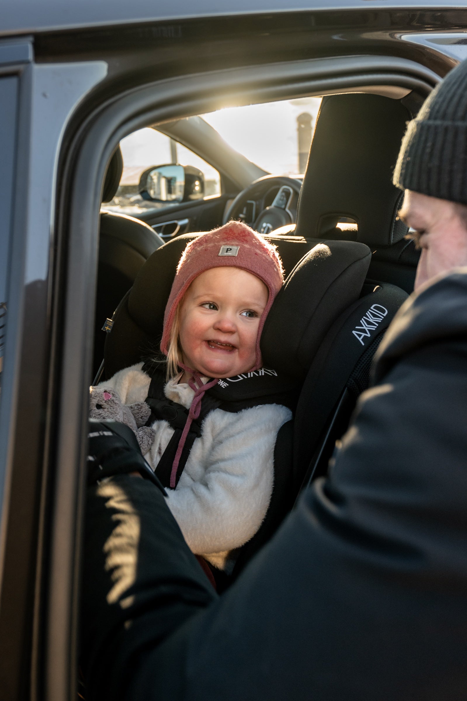 Child in the Axkid ONE 3 with the car door open